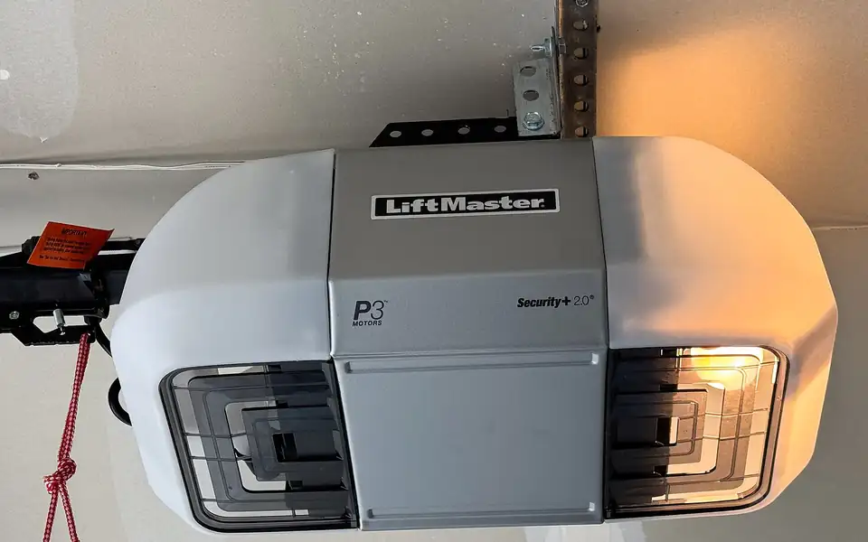 A modern garage door opener with built-in lights on a garage ceiling